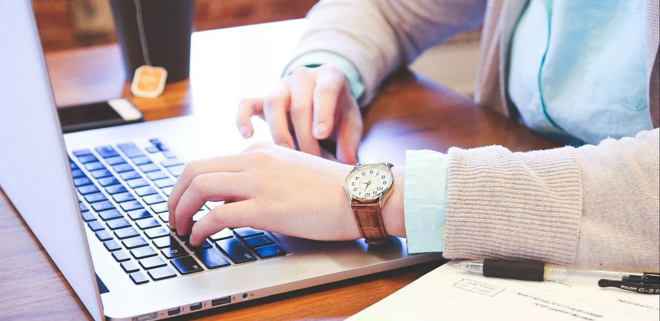 A person is pressing keys on keyboard of a laptop